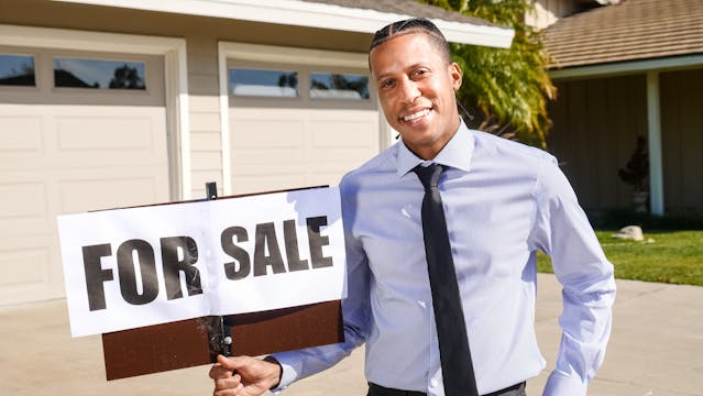 real-estate-agent-holding-home-for-sale-sign